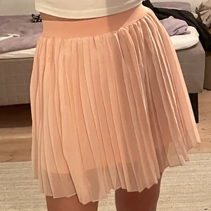 Plisserad kjol - Rosa plisserad kjol från na-kd. Storlek xxs men väldigt stretchig så skulle passa upp till s. Bra skick!! Frakt 48kr.