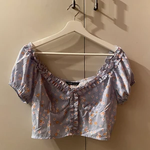 Blommig topp - Blå topp med blommor från Shein. Öppnas/stängs med  dragkedja på baksidan. Säljer då den inte passar på mig. Kan mötas i Stockholm eller skicka. Köparen står för frakten (spårbar) 💗