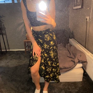 Svart kjol Gina tricot - En svart kjol med gula blommor från Gina Tricot i storlek 34. Den är inte använd speciellt mycket och därmed i bra skick. 