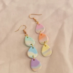 Örhängen - nr 41 - Regnbågesfärgat mönster. Handgjorda örhängen av polymer lera med guldhänge, ca 5-6 cm i längd. 49kr + 20kr frakt 