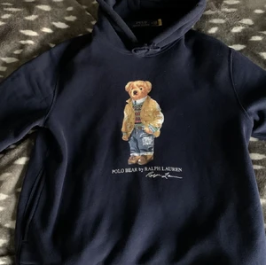 Marinblå (mörkblå) Ralph Lauren Polo Bear Hoodie i storlek Medium (M) - 4 månader gammal Ralph Lauren tröja i storlek M. Färgen är marinblå (mörkblå) och är knappt använd då den är lite stor. Originalpriset ligger på 1500-1900kr just nu, och köptes för 1500kr. Säljpriset på 700kr är ganska fast då tröjan är i perfekt skick.
