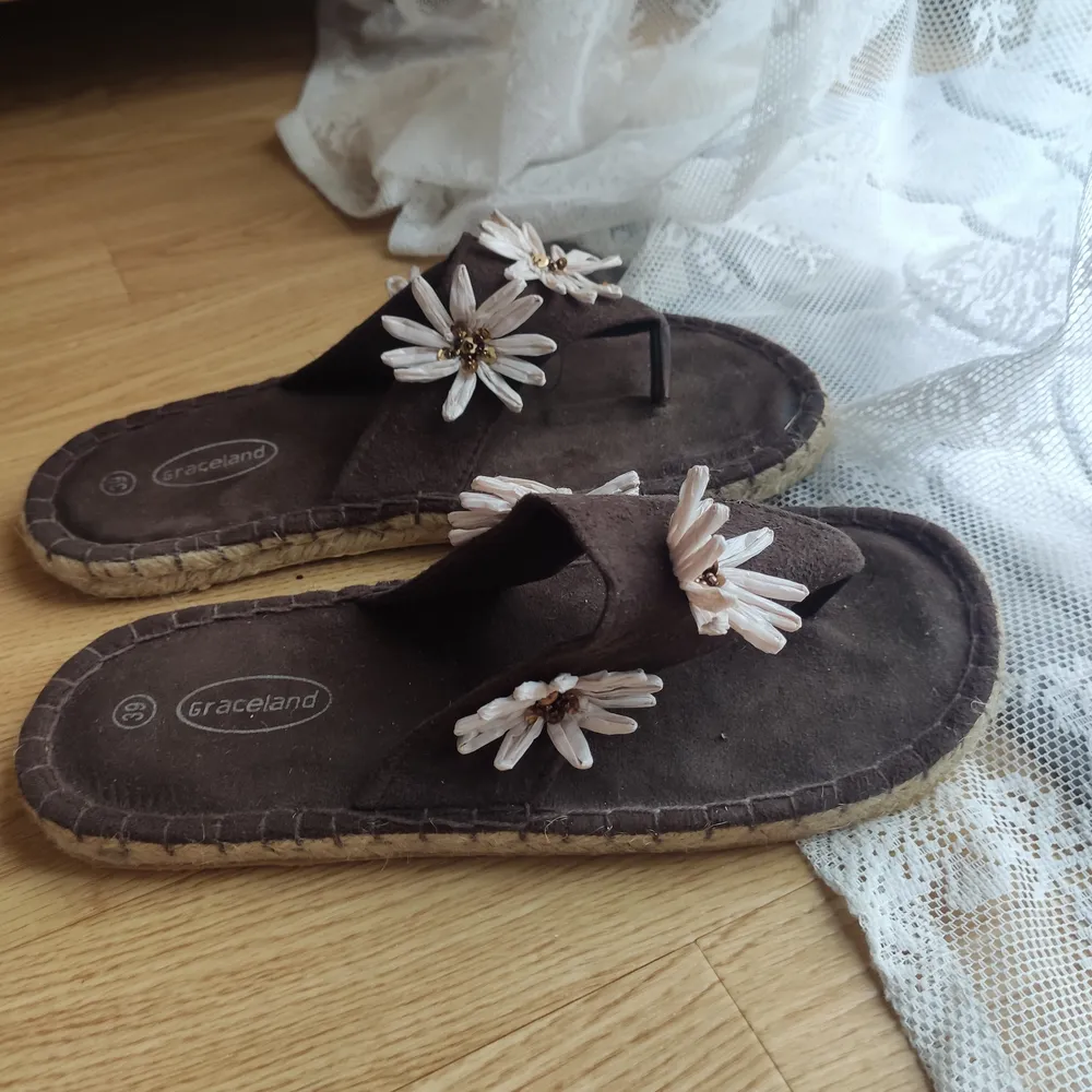 Söta, bruna y2k sandaler med blekrosa blommor. Sulan är flätad och undersidan är av gummi. De är i fint skick. Köpare står för frakt! Går absolut att förhandla om pris✨. Skor.