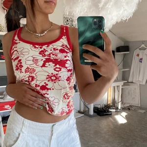 Vitt linne med rött mönster - Säljer mitt skitcoola o fina vintage linne då jag inte använder det så mycket, linnet är i superskick💕 storleken på linnet är S men passar också någon med M😍 buda gärna!Kolla gärna in min profil om du hittar något mer fint❤️