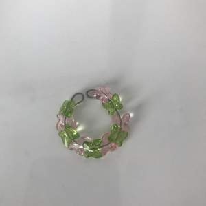 Ring gjort av ståltråd och har rosa o gröna fjärilar🌸🌿 Ringen är öppen och då justerbar så den passar alla fingrar!