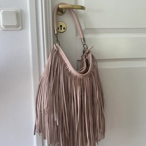 Ljusrosa handväska - En super gullig handväska i en ljusrosa färg. Både långt axelband och kort tillkommmer, det långa går att ta av. Mycket rymligt. Köp från hm