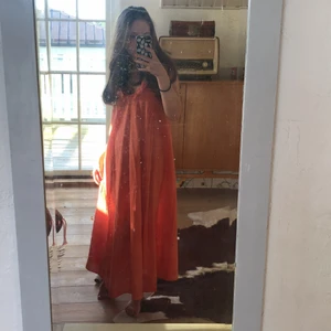 Orange klänning  - Somrig och fin orange klänning från H&M. Med volang på axelbanden. Ganska lång. Kommer ej till användning!
