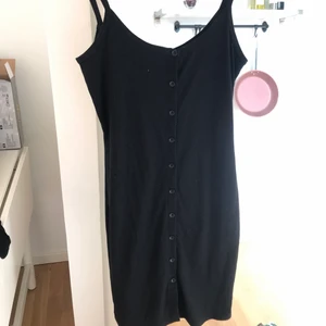 Tight svart klänning - Jättefin tight svart sommarklänning med knappar framtill! Storlek small.