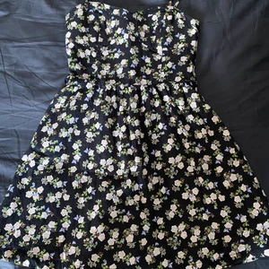 Blomming bustier klänning - Jättefin klänning till sommaren. Säljer för att den ej kommer till användning och tar plats i garderoben. Klänningen har en dragkedja på ena sidan som syns på bild tre. Köparen står för frakt men kan även mötas 