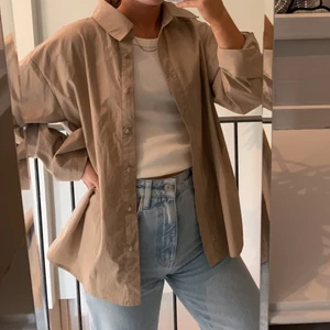 Brun skjorta från NA-KD - Säljer denna bruna skjorta från NA-KD. Den är helt oanvänd så mycket fint skick. 100kr + frakt