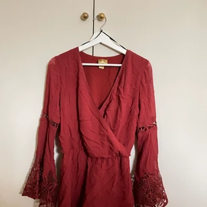 Röd jumpsuit strl. 34 - En röd/mörkröd jumpsuit från h&m i storlek 34. Använd väldigt få gånger. V-ringad med vida ärmar. Säljer för 50kr + frakt.