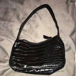 En svart axelväska  - Har kommit till användning i gång och är från Shein som är ganska liten men inte så.