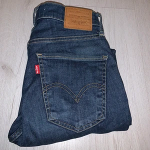 Levis jeans  - Säljer mina mörkblåa jeans från Levis för att den inte kommer till andvändning längre. Köpte dem för ungefär 1 år sedan och dem är i bra skick förutom att det är ett litet hål typ längst ner på högra benet ( bild 3 ) men som man inte tänker så mycket på och som man lätt kan sy ihop igen!😊