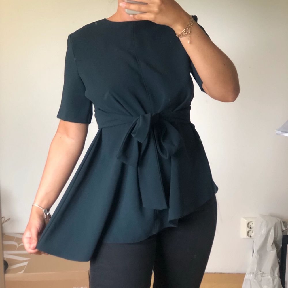Snedskuren Grön blus från ZARA med knytning i midjan. Använt ett fåtal gånger, superfint skick! Kan skicka frakt tillkommer . Toppar.