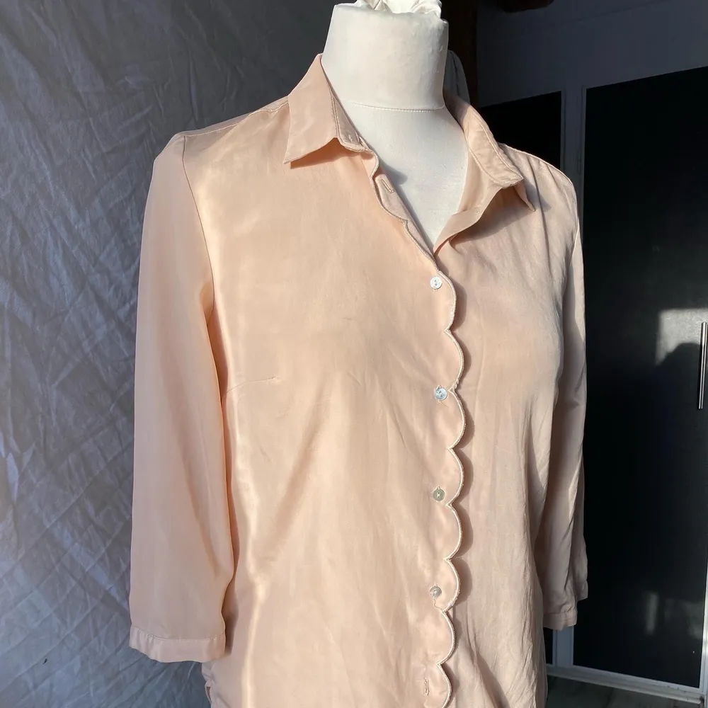 Ljusrosa blus med gullig design från H&M! Blusen är normal i både passform och storlek och har ett mjukt tyg. Frakt tillkommer!. Blusar.