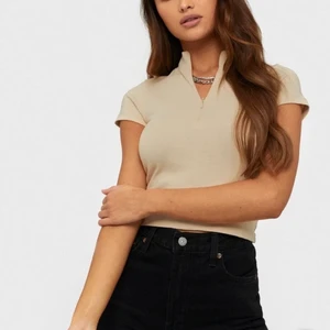 Zip-up tshirt🤎🤎 - Säljer dessa fina zip up t-shirts från Nelly i både beige och vit, använda ett fåtal gånger sågott som i nyskick. Nypris 250kr st🤎🤎