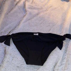 Bikini trosor  - Svarta oanvända bikinistrosor med knytningar på sidan från Kappahl, storlek 170 men passar S 