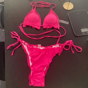 Helt ny och oanvänd rosa bikini från Shein storlek L (S/M) - Helt ny och oanvänd bikini från SHEIN. Storlek L men är liten i storleken.  Säljer då bikinitoppen var för liten för mig. Jag har C-kupa och den passade men det var lite liten för min smak. Ribbat material.  Skrikrosa färg. Mer åt det lila-rosa hållet i verkligheten. Originalpris 89 kr.