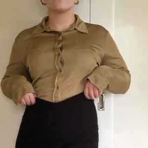 Guldig skjorta! - Skjorta i guldfärg. Sydd i glansigt tyg. 👑 I fint skick. Långa ärmar. Märkt i strl XL men skulle absolut säga att den passar mer som en M/L. Skulle även funka för S beroende på hur man vill att den ska sitta. Jag har ofta M för referens. ⭐️ 