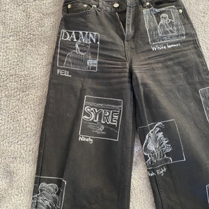 Svarta jeans  - Svarta jeans från Junkyard med albumomslag som är ritade med textilpenna. 
