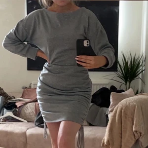 Grå klänning i jearseymaterial stl 36 - Superskön grå klänning i jearseymaterial med drawstring på kjolen. Tyvärr för stor på mig och skulle nog passa M/L. Köpte för 209kr och tyvärr endast testat den. Köparen står för frakt.