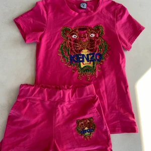 Kenzo - Säljer detta Kenzo-set.  Logoen är i glittrande paljetter, där ingen har fallit av.  Det har använts lite av mig.  Det finns en liten fläck på vänster sida av shortsen som visas på den sista bilden.Försälj helst tillsammans
