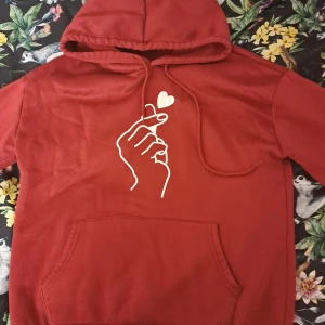 Vinröd hoodie/luvtröja - En vinröd hoodie/luvtröja med finger heart tryck  Använd ett par gånger ☺️