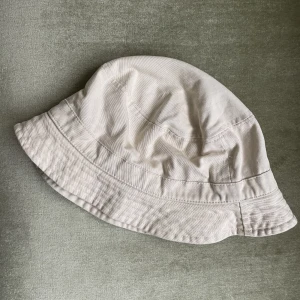 Beige buckethat - Beige buckethat som inte kommer till användning. Inga defekter.