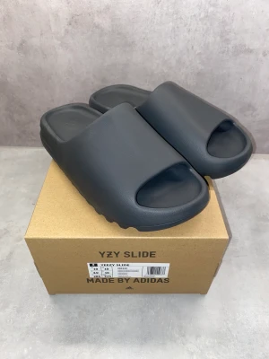 Yeezy slide granite - Yeezy slide granit i storlek 44 1/2, tofflorna är aldrig använda.