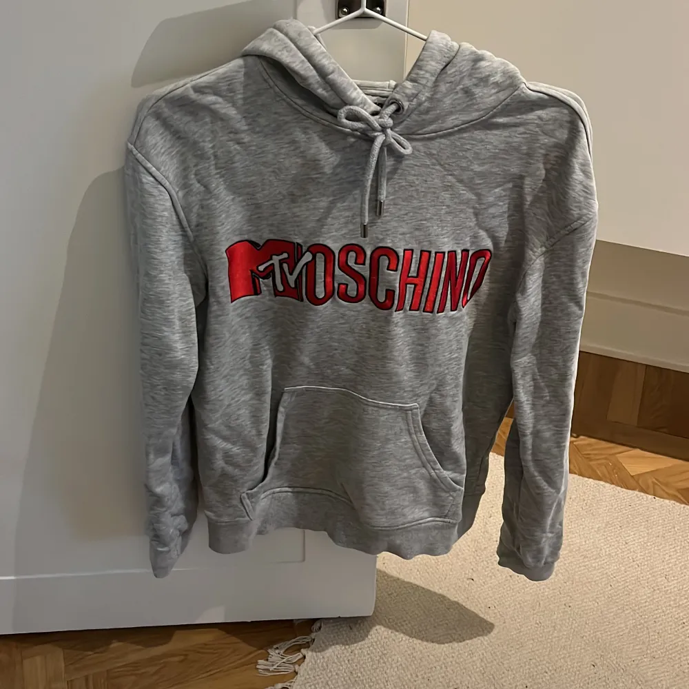 Grå HM x Moschino hoodie i storlek XS. Skulle säga att den även passar S. Köpt här på Plick för många år sen. Inga synliga fel. Hoodies.