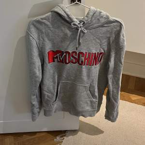 Grå HM x Moschino hoodie i storlek XS. Skulle säga att den även passar S. Köpt här på Plick för många år sen. Inga synliga fel