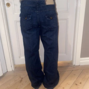 Lågmidjade jeans - Lågmidjade mörkblå jeans med vida utsvängda ben och nice fickor🤩 Perfekt skick! Storleken passar en L. Skriv vid funderingar och kolla in mina andra annonser💓