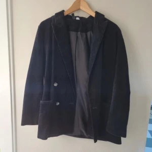 Svart manchesterkavaj  - Svart manchesterkavaj i strl 38. Oanvänd, bara hängt i garderoben. Är varm så man kan ha den som höstjacka.
