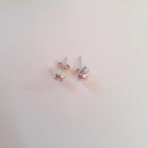 Silverörhängen  - Örhöngen i äkta silver med en blomma ingraverad. Helt oanvänd och i nyskick. Ask: 10 kr (valfritt) Frakt: 15 kr