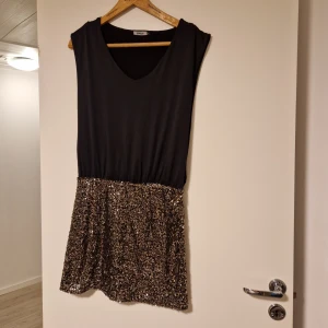Kort festklänning - Kort festklänning med paljetter nedtill. Den är från only i strl S. Använd en kväll så den är som ny.
