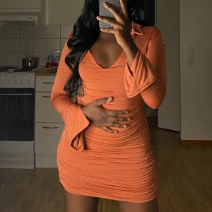 Långärmad klänning med krage - Jag säljer en aprikosfärgad långärmad klänning som är använd en gång. Klänningen har en jättefin passform på både midjan och rumpan! 🫶🏾