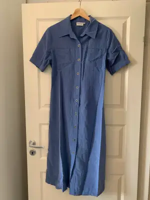 Blå vintageklänning med knappar. Midi längd. Fin siluett.