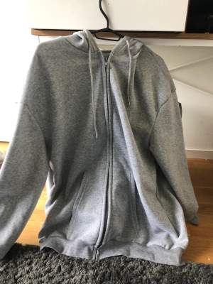 En grå zip up hoodie från shein, aldrig använt. tunt material .
