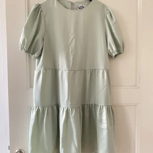 Klänning  - Säljer denna klänning köpt på Asos, från märket Lola May!  Superfint tyg, satinintryck med puffärmar & ”volangkjol”. Färgen är salviagrön 🩵