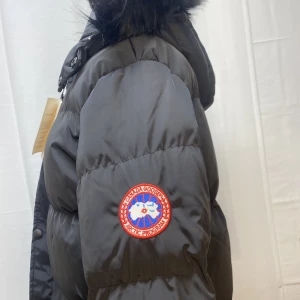 Canada Goose Jacka - Lång Canada Goose jacka. Den är inte äkta men ser autentisk ut. Storlek XXL men skulle kunna passa mindre storlekar också. 
