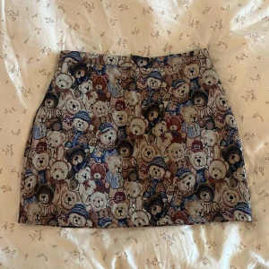 Kjol med söta nallebjörnar på - Söt kort kjol med nallebjörns-mönster. Köpt från Cider, aldrig kommit till användning tyvärr. Som ny! Är i storlek L, men mindre än vanligt!🐻✨