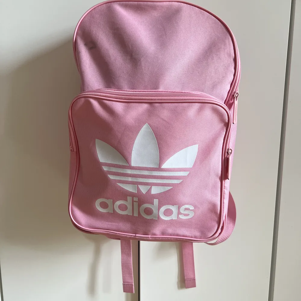 Ljusrosa Adidas ryggsäck. Rymlig, liten fläck uppe till vänster men annars ren. . Väskor.