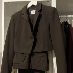 ZARA SET - Mörkbrunt SET från ZARA, rutigt. Använd någon gång, mycket bra skick. Bara att höra av sig om fler bilder efterfrågas. Byxorna är långa i modellen.