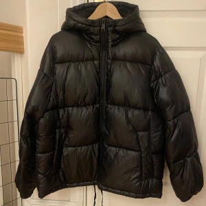 Pufferjacka med luva - Jag säljer min pufferjacka från Hm, det är den svarta glansiga ”puffern med huva” då den blev lite stor. Den är änvänd några få gånger, fortfarande i nyskick och superfin. Org pris 499kr. Skriv för mer info💕