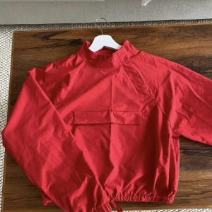 Set från NAKD - Fint tvådelat set från NAKD. Överdelen är croppad och har en ficka på bröstet samt dragkedja snett bredvid halsen. Svårt att få till en rättvis bild gällande färg, upplever den ljusare i verkligheten. Nederdelen något högre i midjan.