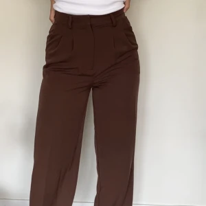 Bruna kostymbyxor  - Fina högmidjade kostymbyxor från bikbok i storlek S! Perfekt längd för mig som är 170 cm. Sköna och mjuka