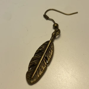 Örhänge - Ett örehänge i form av en fjäder som jag aldrig kunnat använda💗 köparen står för frakt, bara att ställa frågor och kan självklart diskutera pris 🤗