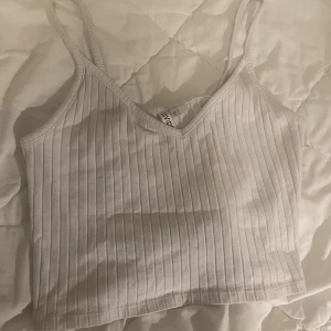 Vit ribbad top - Säljer en vit ribbad topp från Divided/H&M som inte längre säljs, strl S, köpt för ca 100kr säljer för 45kr! 🤍