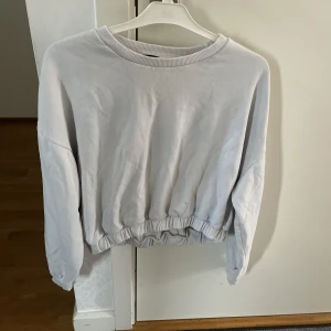 Vit tjocktröja - En vit tjocktröja från Lager 157. Knappt använd, därav fint skick. Den är lite kortare och har även resår lägst ner. 