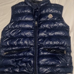 Moncler Väst - Moncler gui väst  Storlek S Skick 8,5/10 Litet hål på ryggen man märker dock inte av om man inte kollar noga. PM för fler bilder och info Pris ej hugget i sten