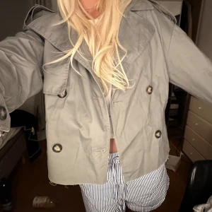 Kort trench - Kort trenchcoat som knappt kommer tills använding. Supersnygg men tyvärr lite för liten för mej